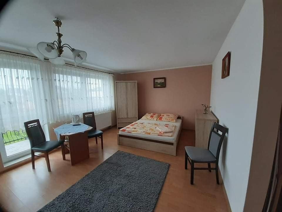 a bedroom with a bed and a table and chairs at Pokoje Bursztynowa in Swarzewo