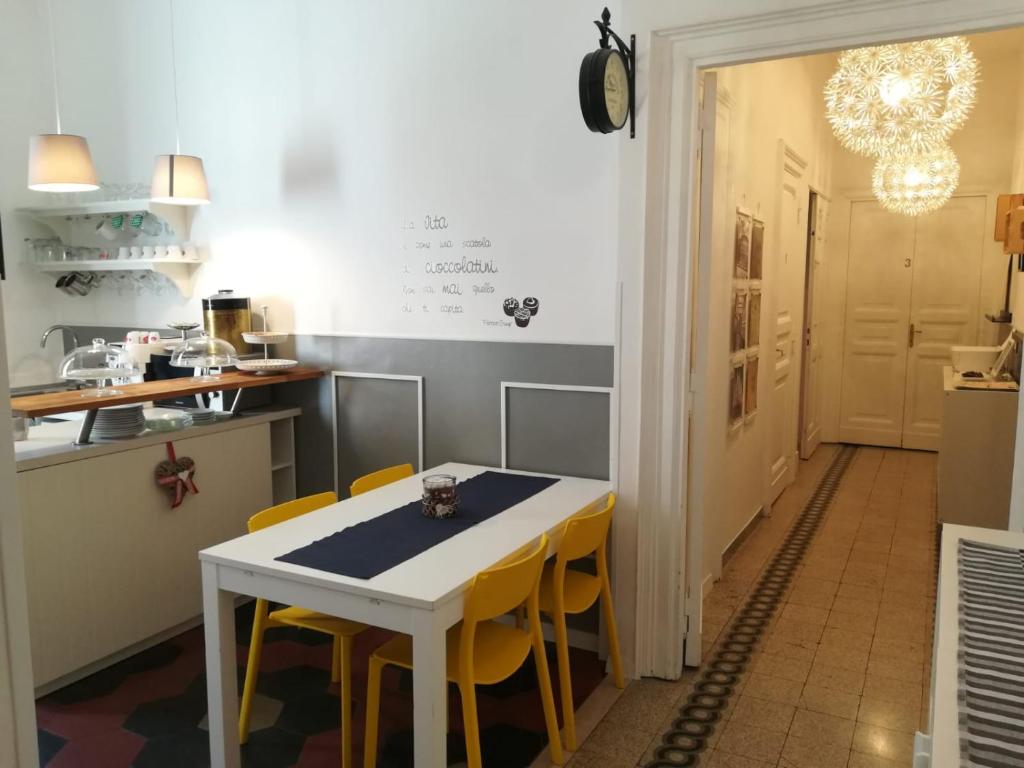 ローマにあるMiRhome Guest Houseのキッチン(白いテーブル、黄色い椅子付)