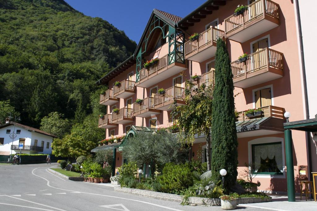 un edificio rosa con balcones en una calle en Club Hotel Tenno, en Tenno