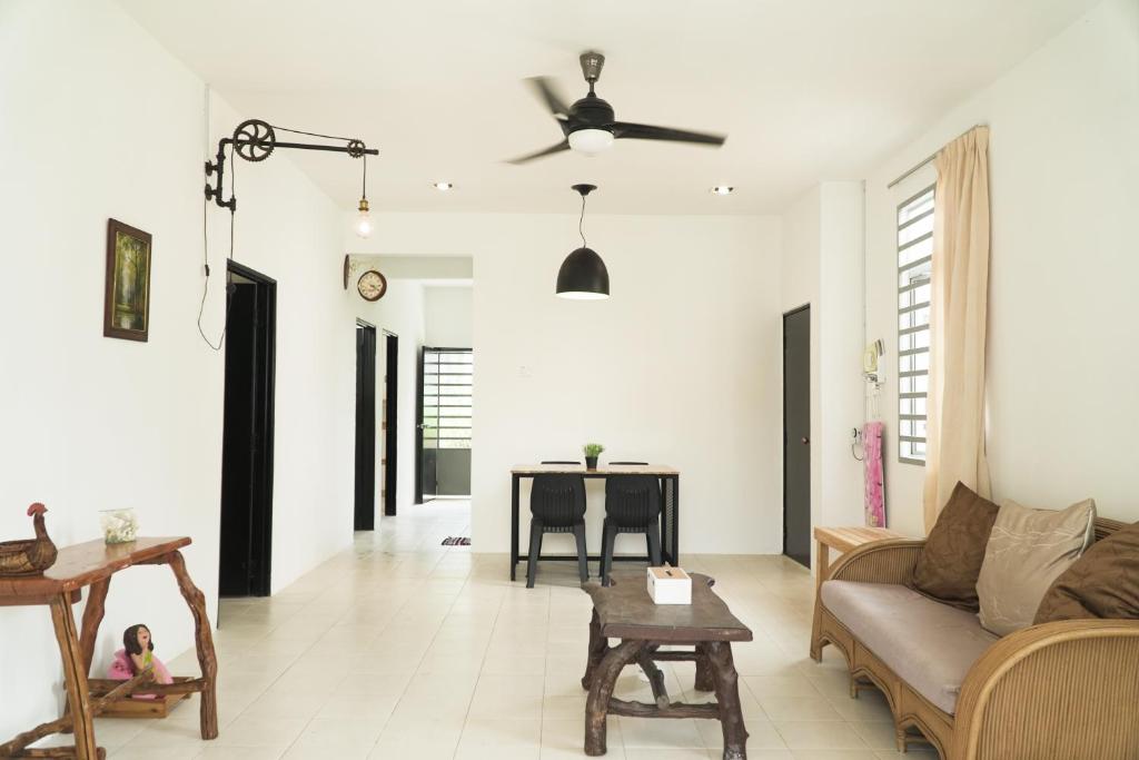 a living room with a couch and a table at Cozy, Spacious, Air Cond UMP Gambang Homestay -- The Pigeon Guest House in Kuantan