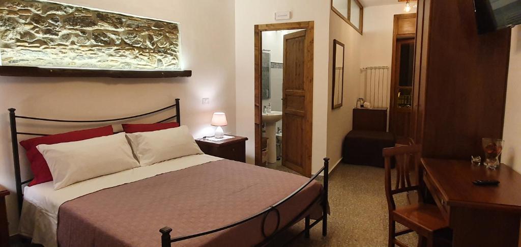 sypialnia z łóżkiem, stołem i biurkiem w obiekcie Il Covo dei Re w mieście Fiumedinisi