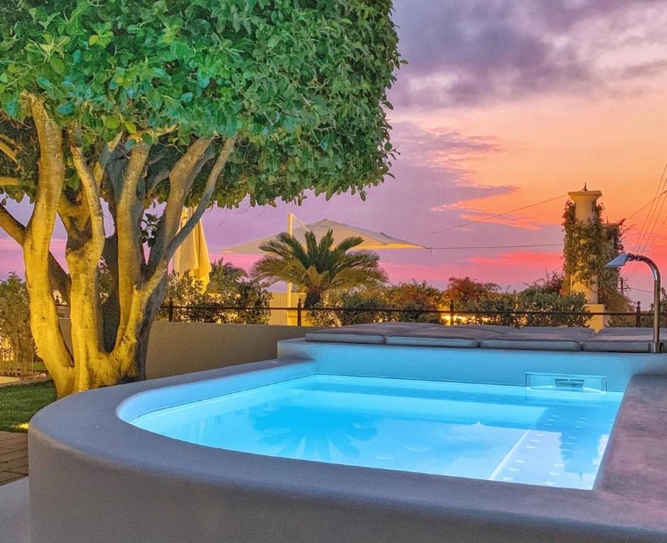 una piscina en un patio trasero con un árbol en La Giuliva Charming Rooms, en Anacapri