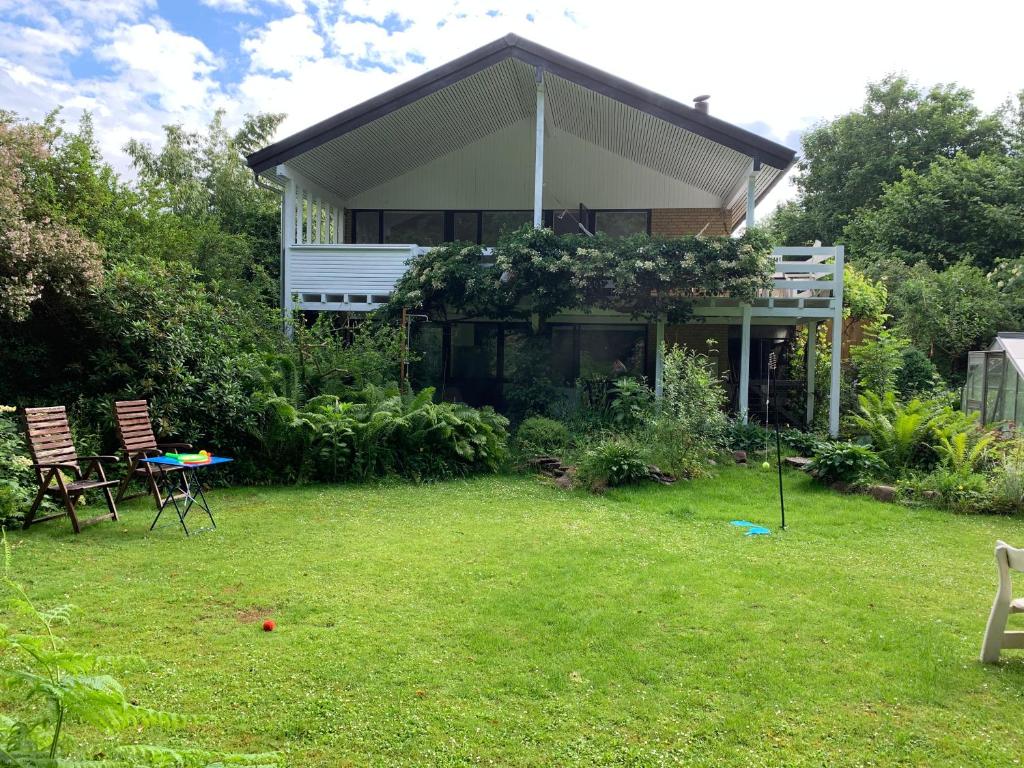 una casa con un patio con 2 sillas y una mesa en Villa 4 rooms, en Hillerød
