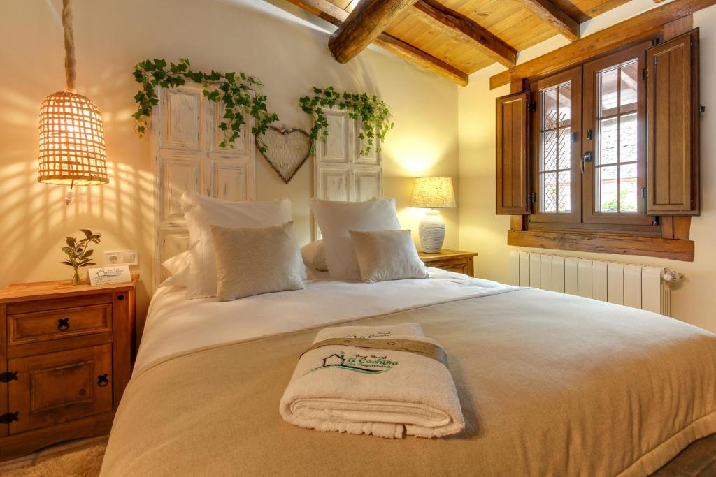 a bedroom with a large bed with a towel on it at Casa Rural A Cashiña da Lagarteira in Valverde del Fresno