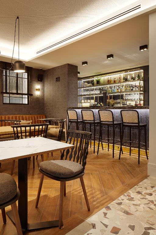 a restaurant with tables and chairs and a bar at Hotel SANSEbay in Donostia-San Sebastián