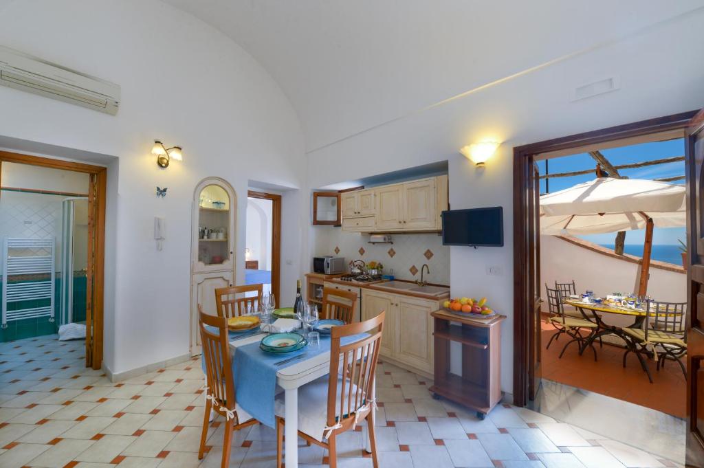cocina y comedor con mesa y sillas en Casa La Verbena, en Praiano