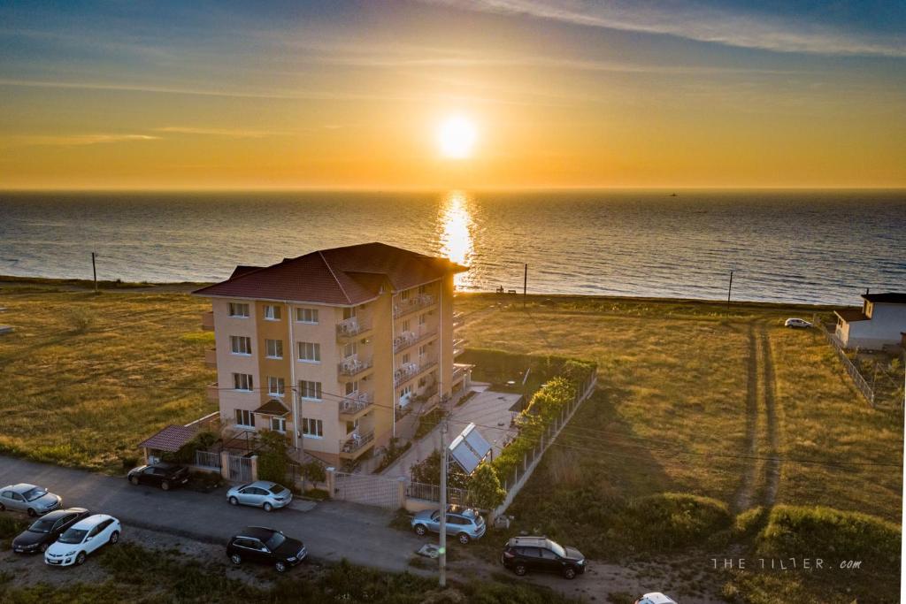 an apartment building with a parking lot and the ocean at Casa Eden in Costinesti
