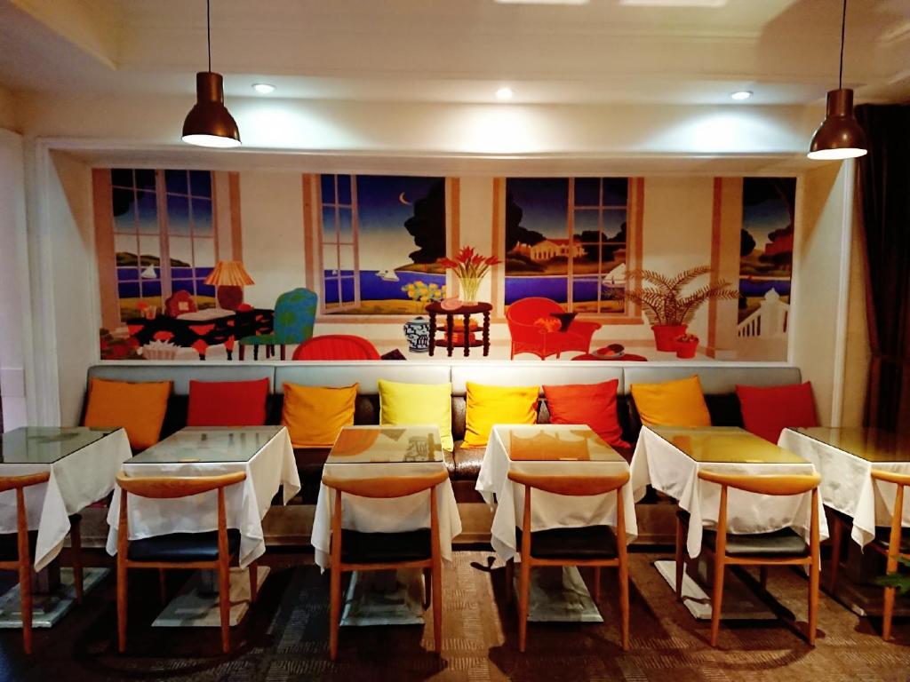 高雄市にある高第商旅 Gaudi Hotelのテーブルと椅子、ソファ付きのレストラン
