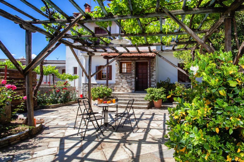 a patio with chairs and a table under a pergola at Erofili's Home in Portaria