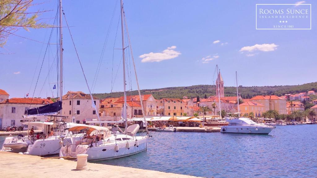 a group of boats docked in a harbor with buildings at ꕥ Apartments Residence SUNCE Supetar, Family choice - cozy base to stay and explore island Brac FREE PARKING in Supetar