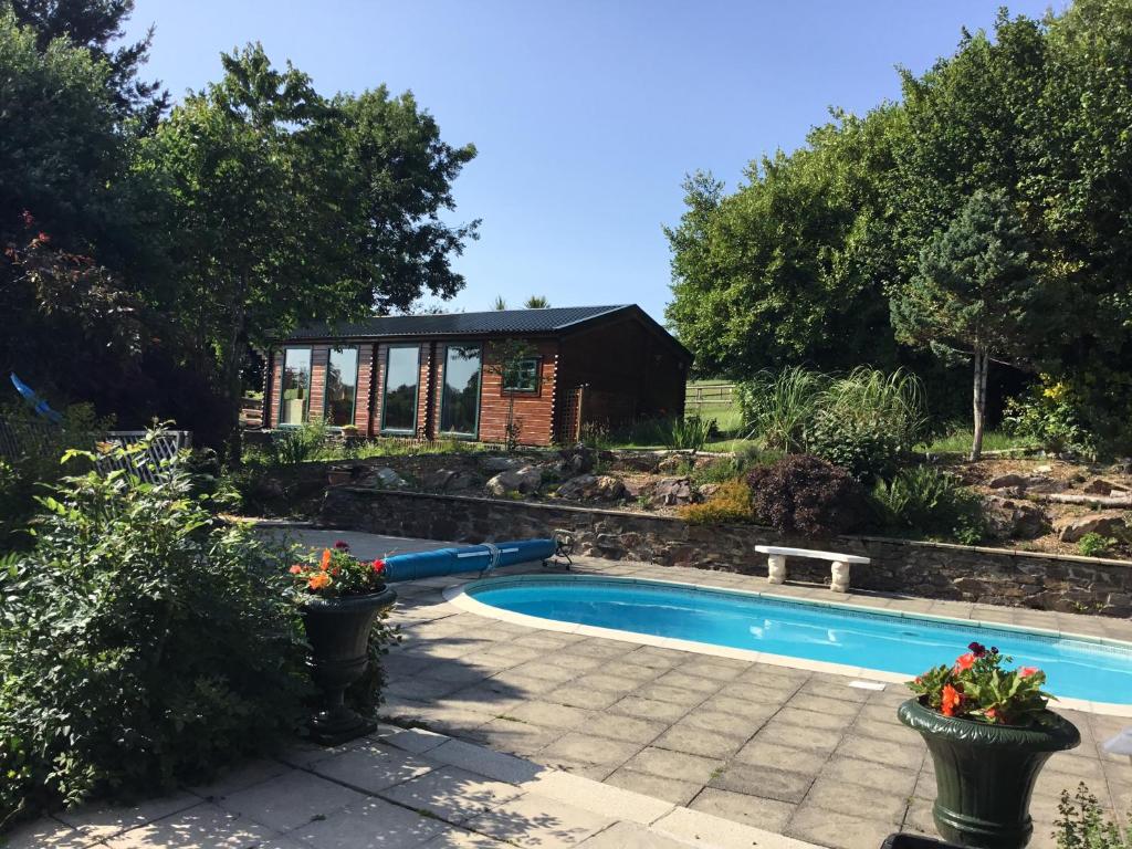 uma piscina num jardim com uma casa em Tudor Lodge em Liskeard