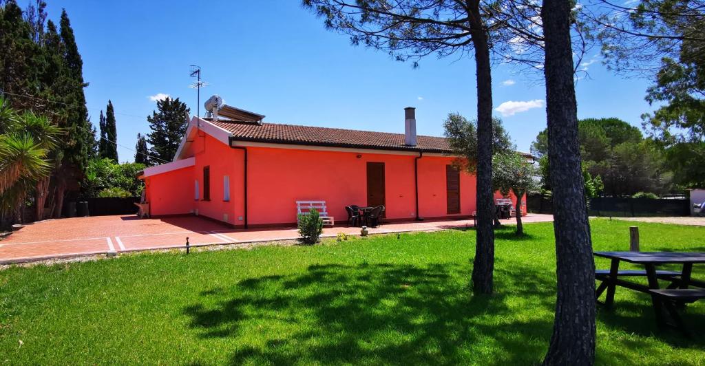 un edificio rojo con una mesa de picnic en un parque en Casa RoSi, en Alghero