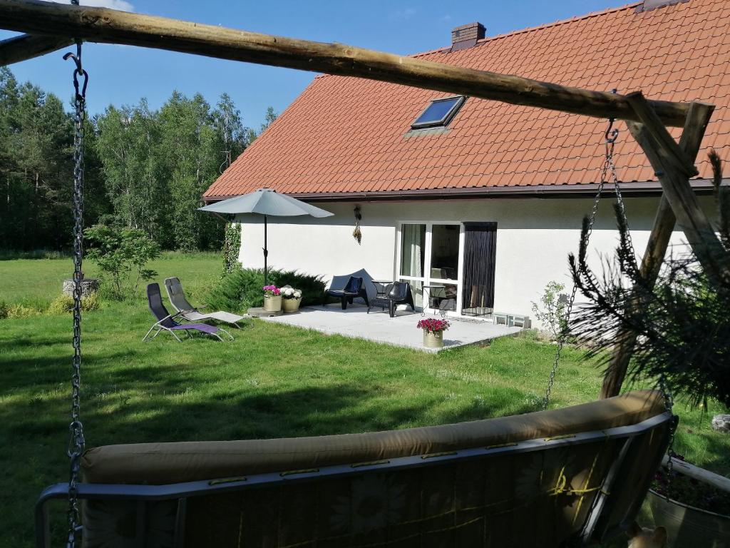 uma casa com um quintal com um baloiço em Agroturystyka TWÓJ KĄCIK em Kurzetnik