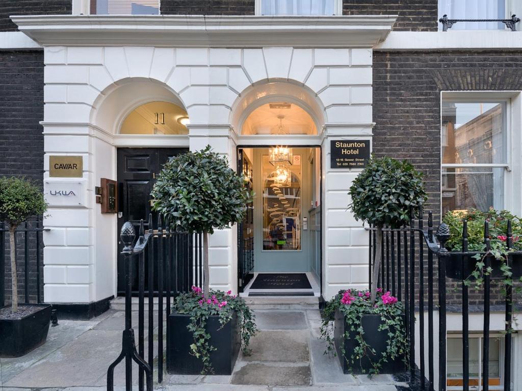 uma porta da frente de uma loja com vasos de plantas em Staunton Hotel - B&B em Londres