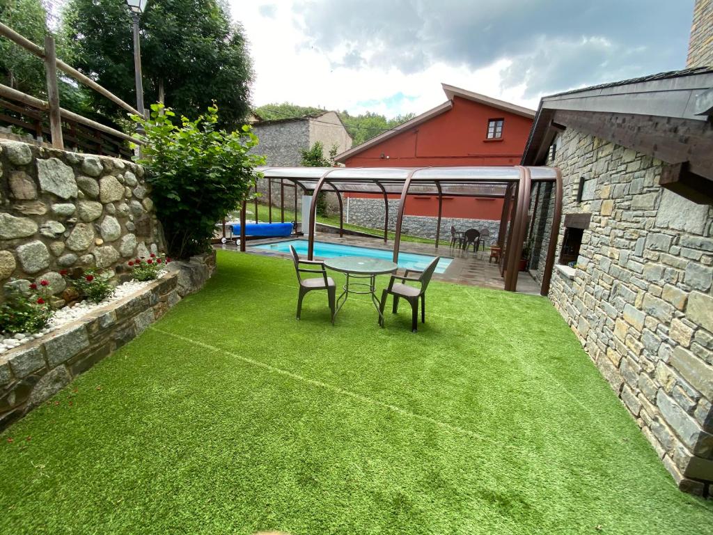 un patio con mesa, sillas y piscina en Hotel Sesué, en Sesué