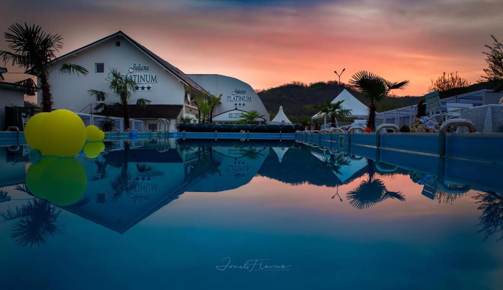 um reflexo de um edifício numa piscina de água em Juliana Platinum Brad em Brad