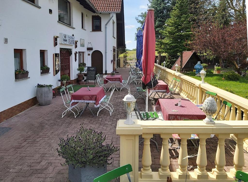 eine Terrasse mit Tischen und Stühlen auf dem Balkon in der Unterkunft Gasthof und Eiscafe Frank in Leimbach