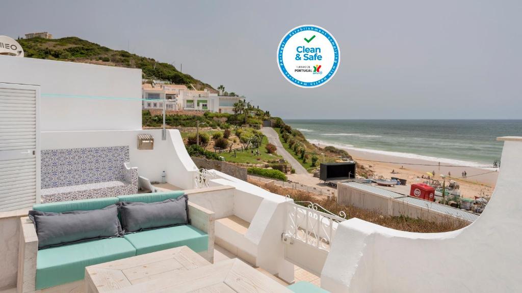 a view of the beach from the balcony of a beach house at Vila Varanda by Sevencollection in Salema