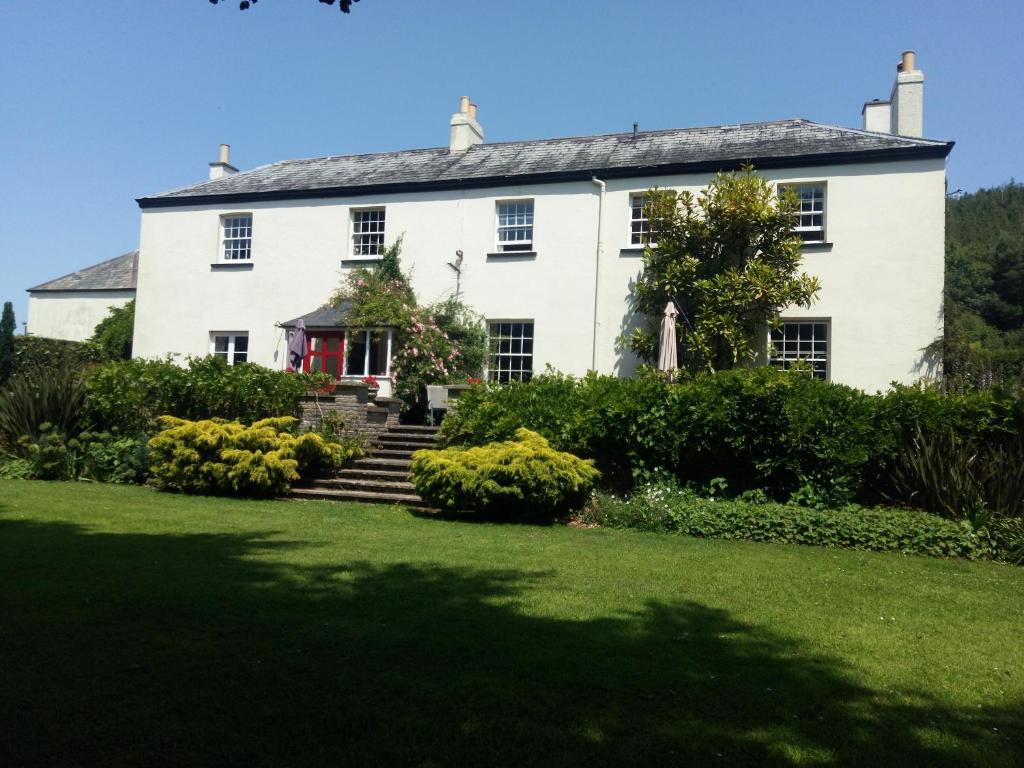 a large white house with a yard at Buckley Farmhouse in Sidmouth