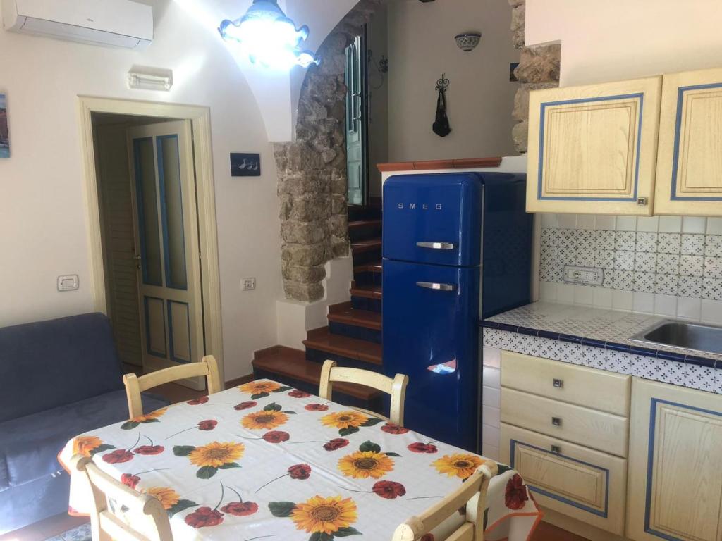 Il comprend une cuisine équipée d'une table et d'un réfrigérateur bleu. dans l'établissement Appartamento Residence Costa D'Amalfi, à Minori