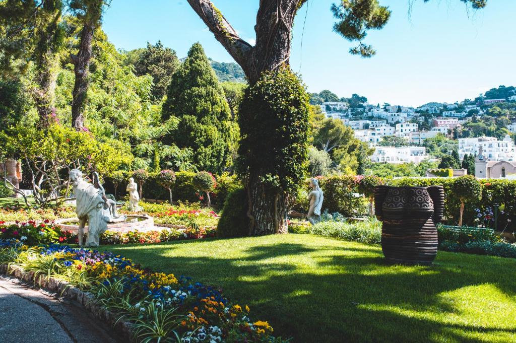 a garden with statues and flowers in a park at Parco Augusto in Capri