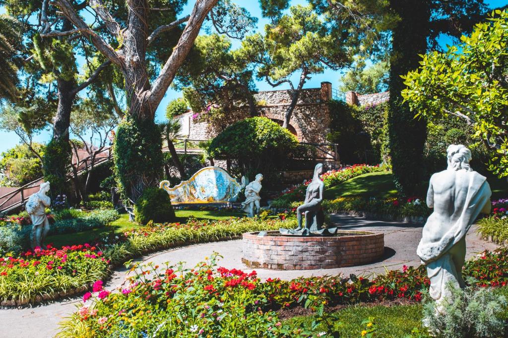 a statue in a garden with flowers at Parco Augusto in Capri