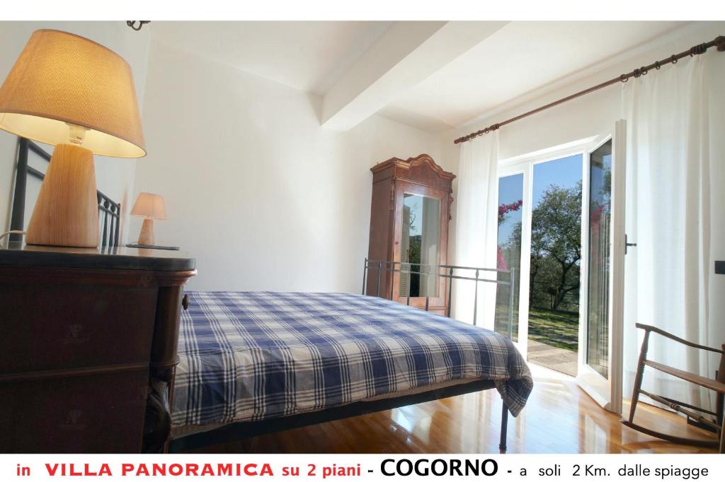 sypialnia z łóżkiem z niebieskim kocem w kratę w obiekcie Appartamento A in villa con vista panoramica w mieście San Salvatore