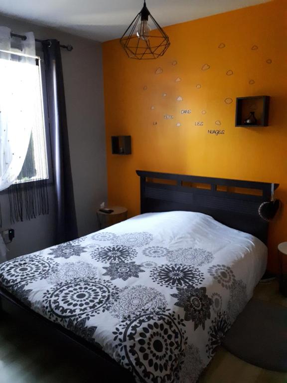 een slaapkamer met een bed met een zwart-wit dekbed bij Chez les catherine in Saintes