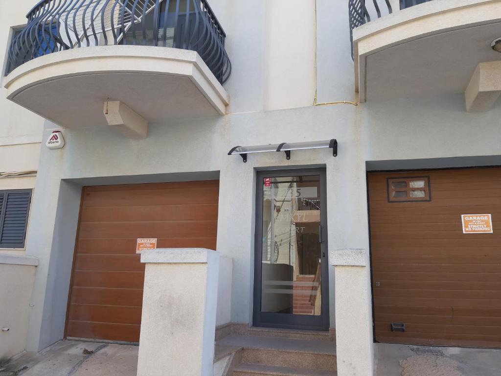 a building with a garage door and a balcony at Penthouse 2 in Marsaskala