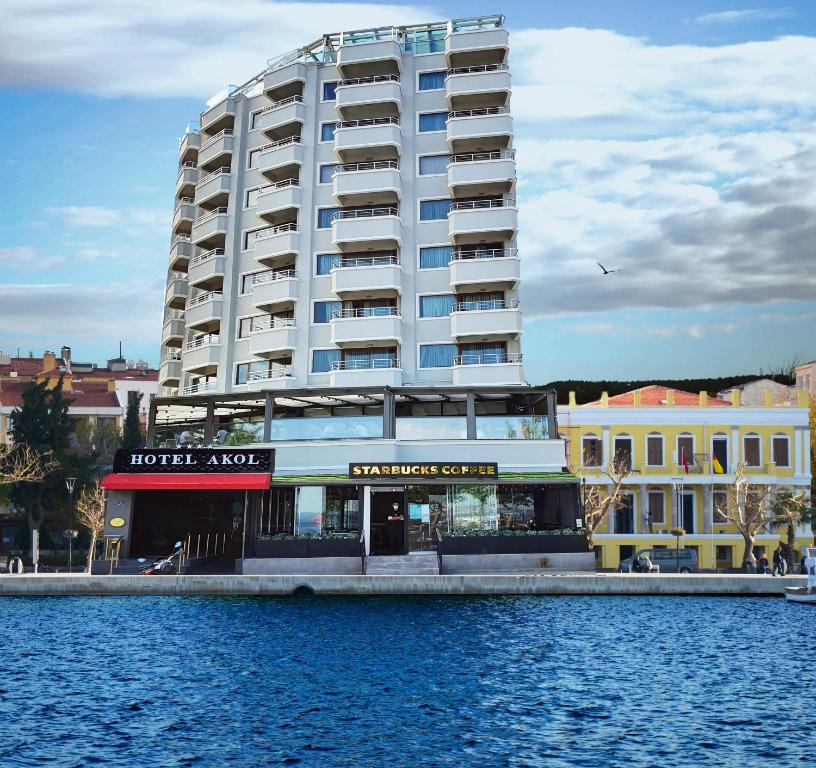 ein großes weißes Gebäude neben einem Wasserkörper in der Unterkunft Akol Hotel in Canakkale