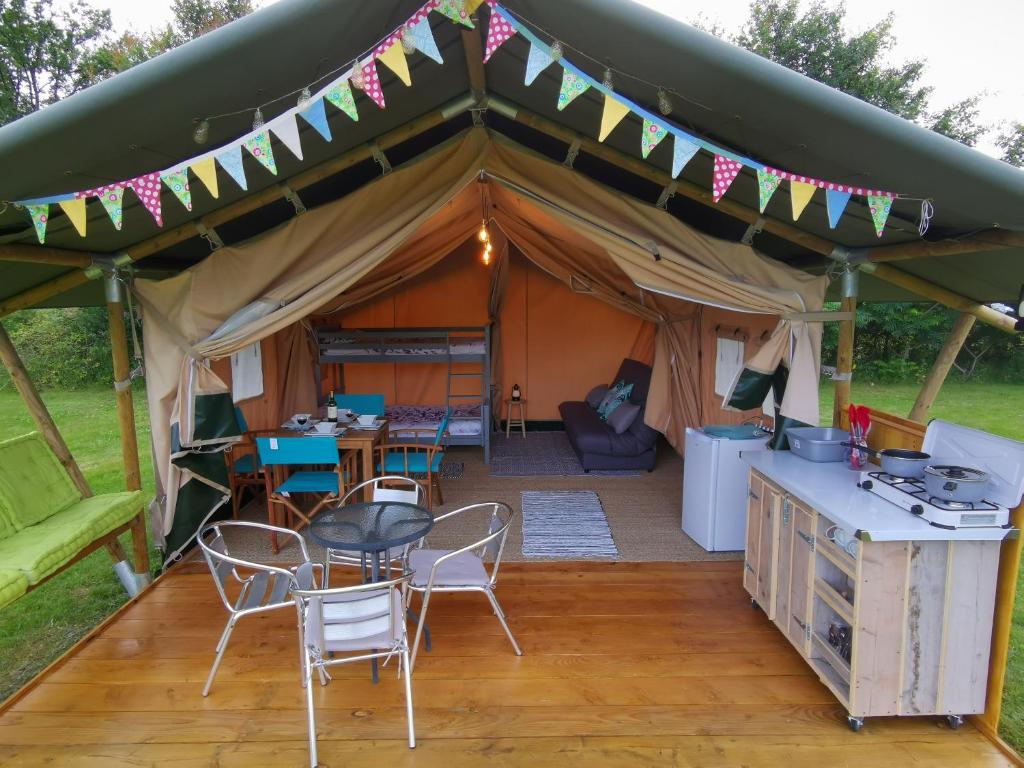 a tent with a table and chairs in it at Safari at La Petite Lande in Pierrefiche