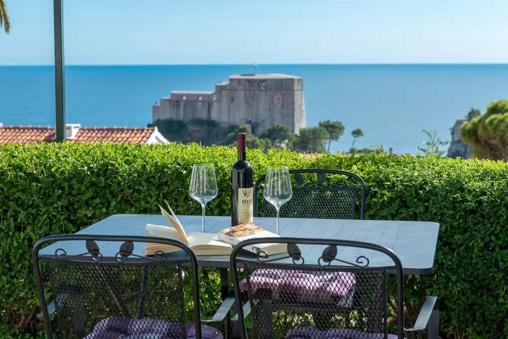 una mesa con una botella de vino y dos copas en Apartment Saint John 2, en Dubrovnik