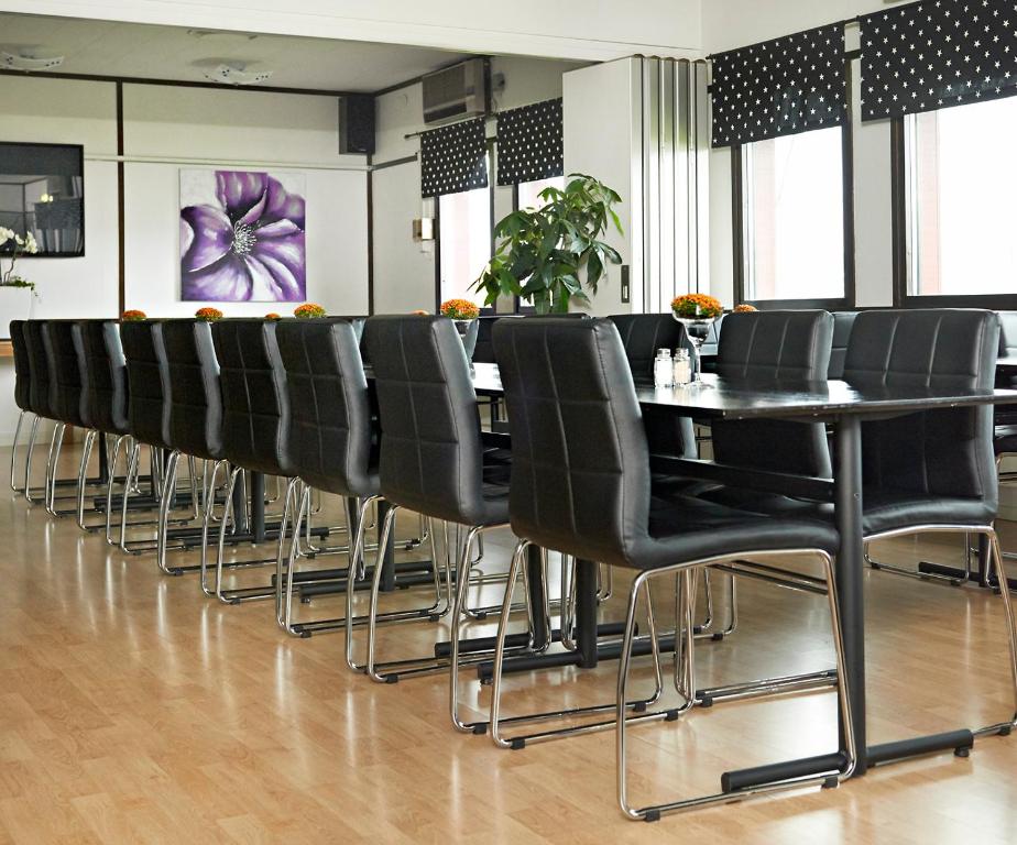 a row of black chairs and a table in a room at Hotel Surte in Surte