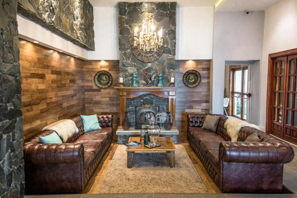 sala de estar con sofás de cuero y chimenea en Hosteria y Restaurante America en Ushuaia