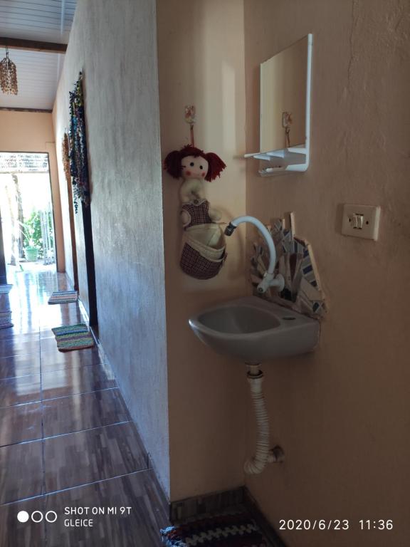 ein Badezimmer mit einem Waschbecken und einem Teddybär an der Wand in der Unterkunft Casa da Praia.Atins in Atins