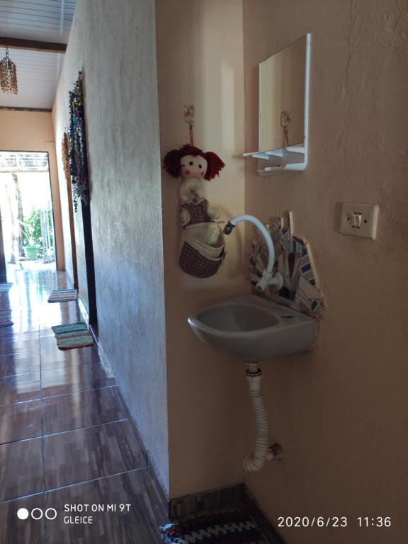 a bathroom with a sink and a teddy bear on the wall at Casa da Praia.Atins in Atins