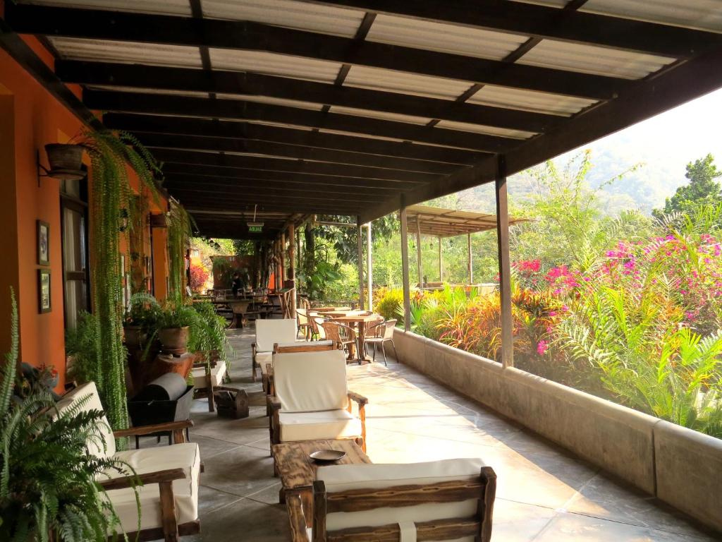 un patio al aire libre con sillas, mesas y flores en Fundo San Jose Parque Ecológico & Lodge Hotel Asociado Casa Andina, en La Merced