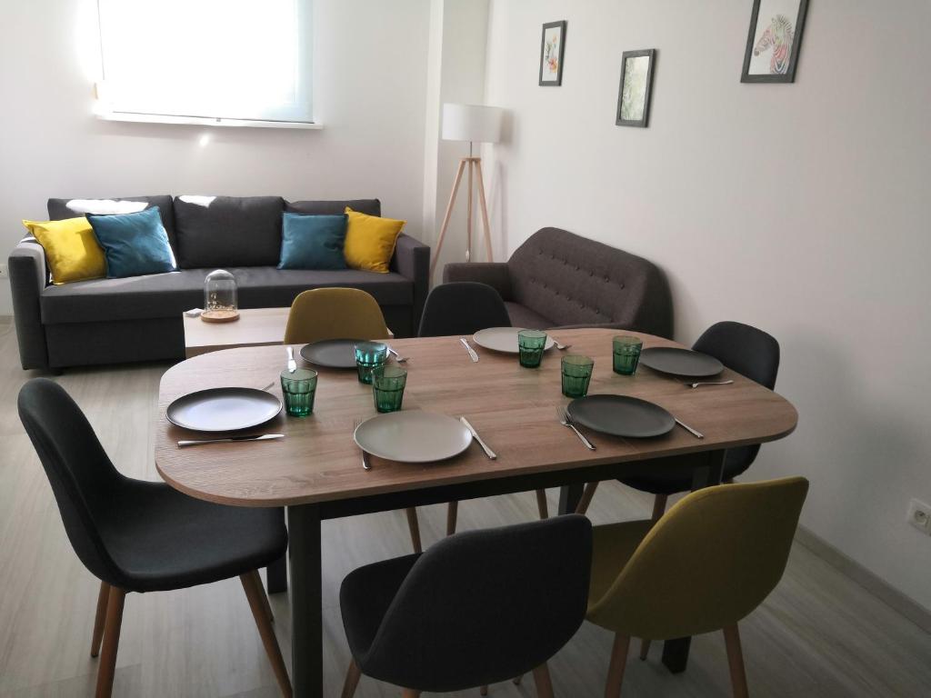 a dining room table with chairs and a couch at Appart' O bernai in Obernai