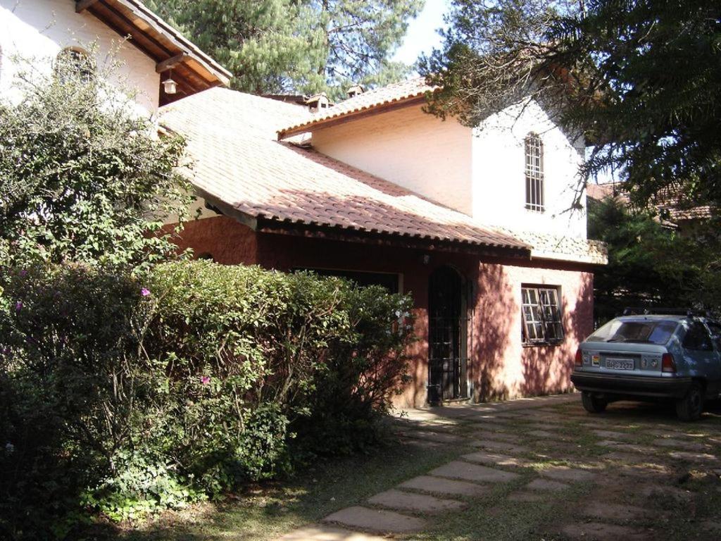 ein Haus mit einem davor geparkt in der Unterkunft Casa das dálias in Monte Verde