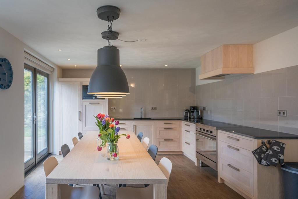 a kitchen with a table with a vase of flowers on it at familiewoning Orchismient 24 in De Koog