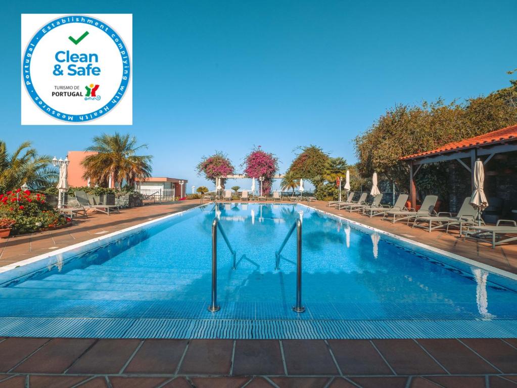a swimming pool at a resort with the clean safe logo at Ocean Gardens in Funchal