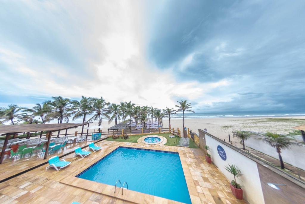 - une vue sur la plage depuis le balcon d'un complexe avec piscine dans l'établissement Milos Beach Hotel, à Aquiraz