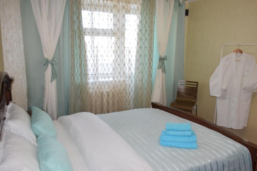 a bedroom with a bed with blue towels on it at Мода в доме 13 in Oral