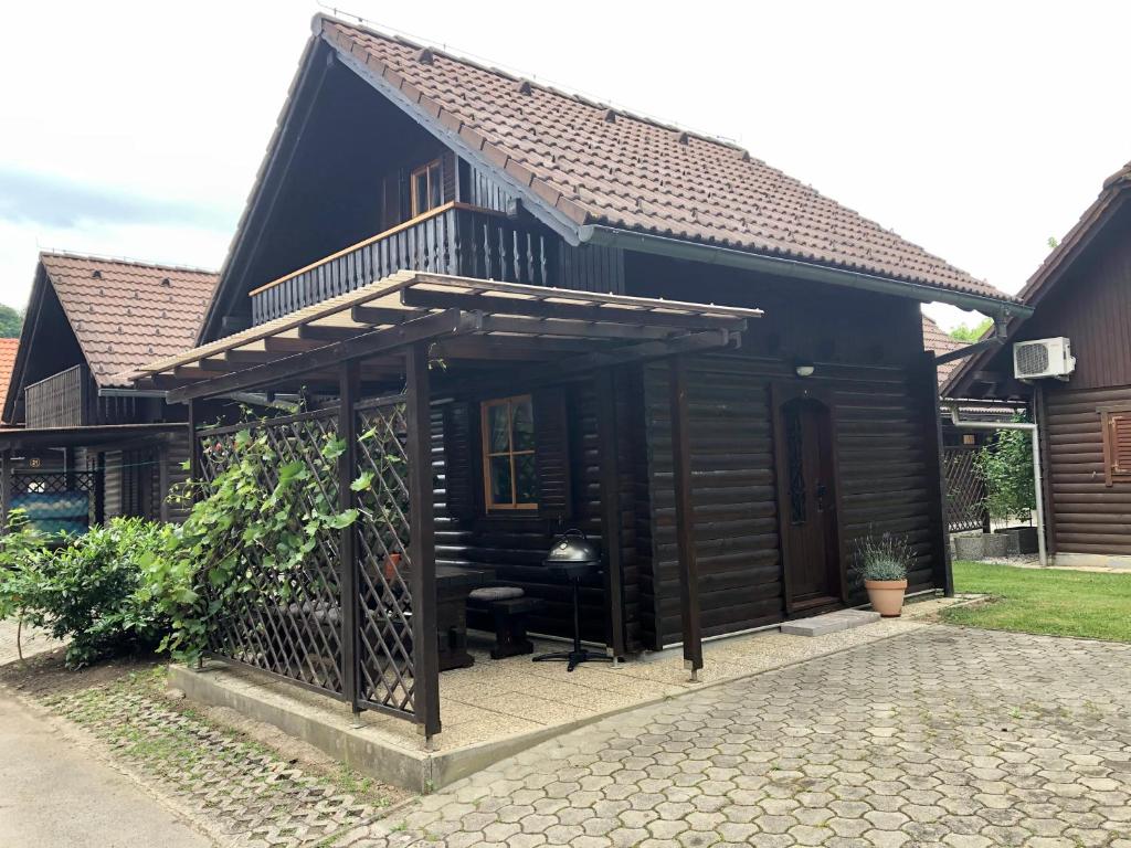 une petite maison noire avec un banc devant elle dans l'établissement Holiday Cottage Krishtan, à Podčetrtek