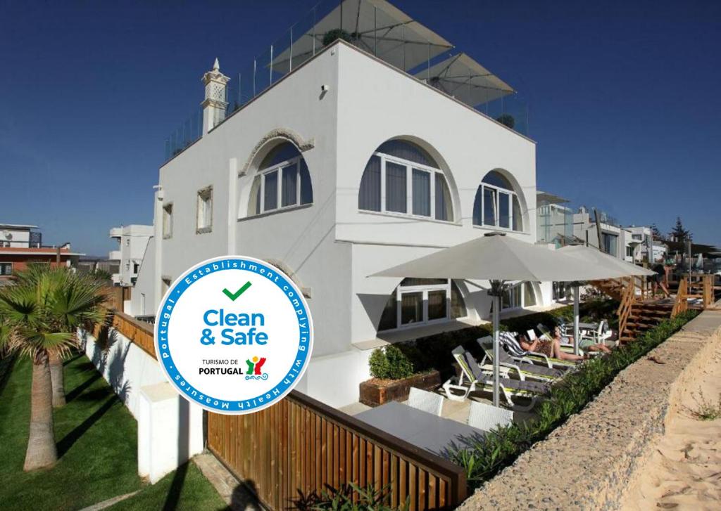 een gebouw met een bord ervoor bij Golden Beach Guest House & Rooftop Bar in Faro