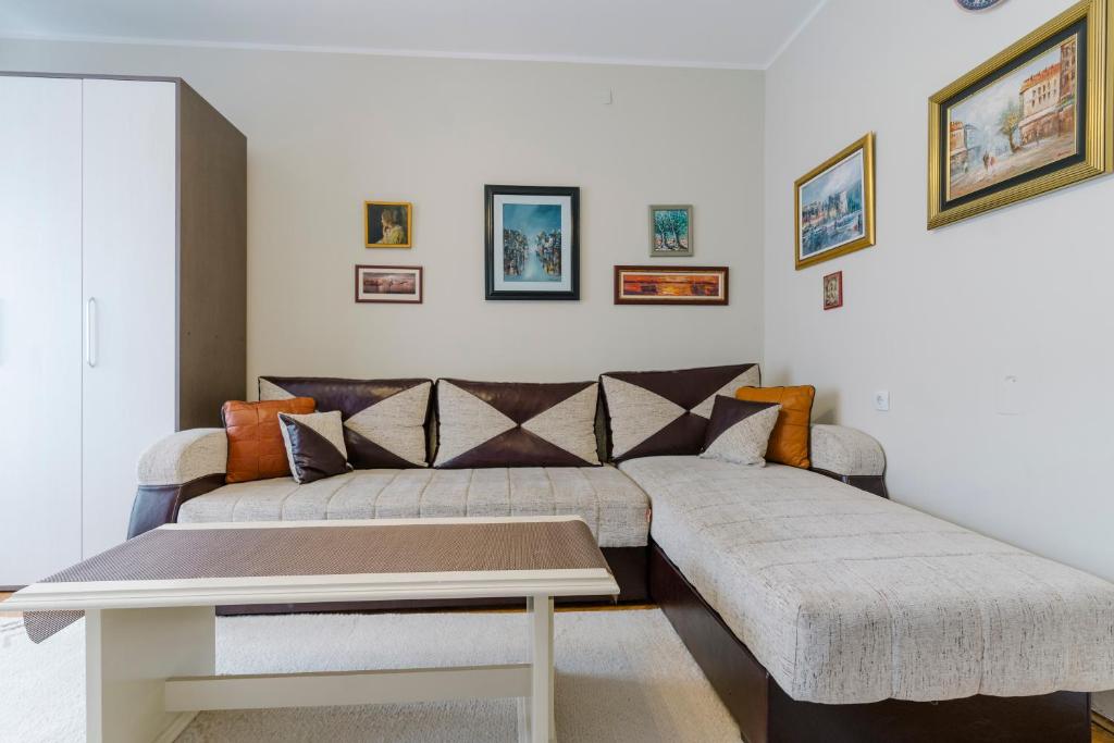 ein Wohnzimmer mit einem Sofa und einem Tisch in der Unterkunft Niš Downtown Residence in Niš