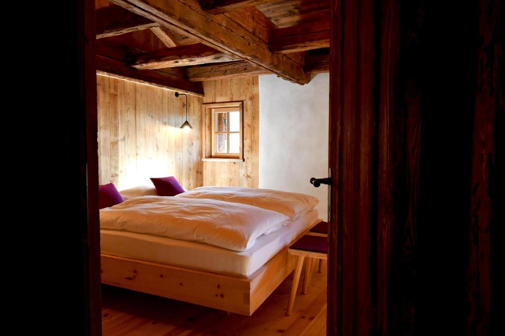 una camera con un letto in una stanza con pareti in legno di Weinhof Haidnerhof a Bressanone