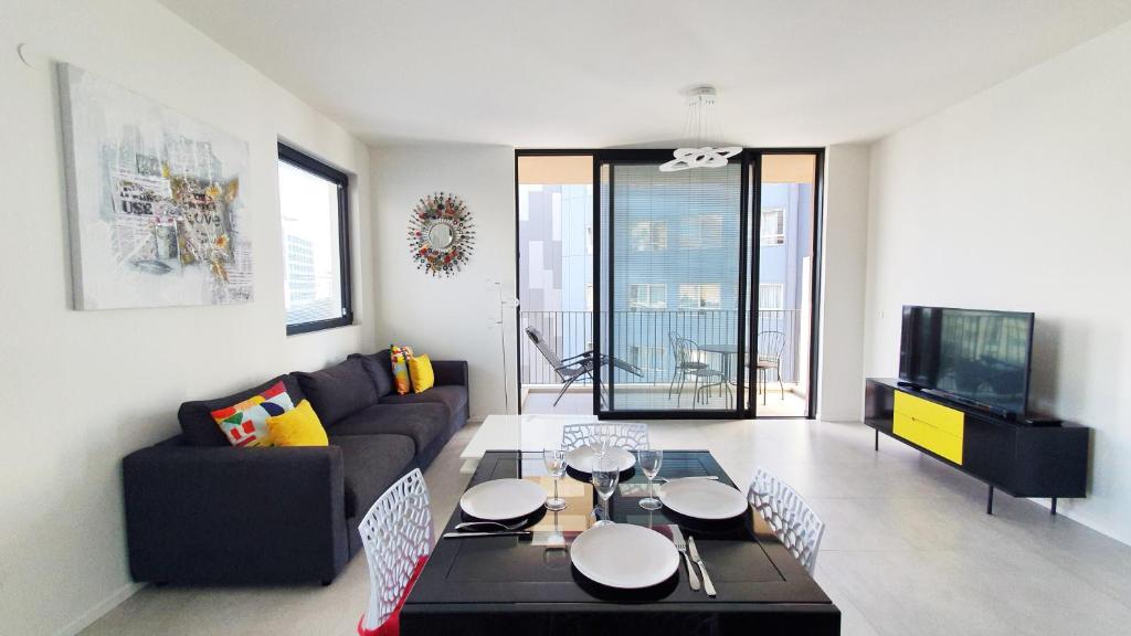 a living room with a couch and a tv at BnB Israel Apartments - Shalom Alehem Joie in Tel Aviv