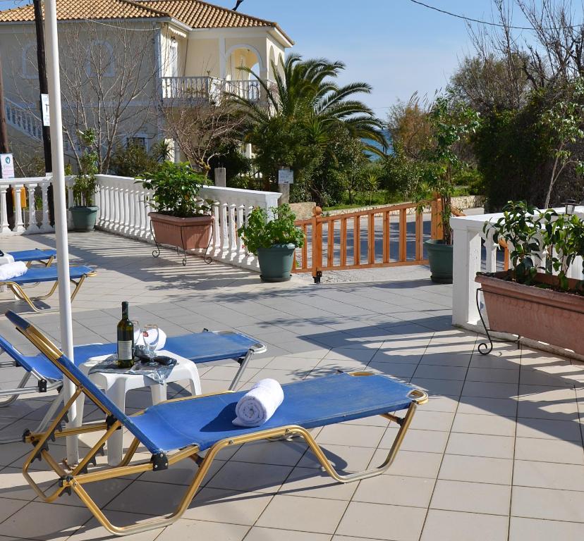a patio with two lounge chairs and a bottle of wine at NIKOS APARTMENTS in Laganas