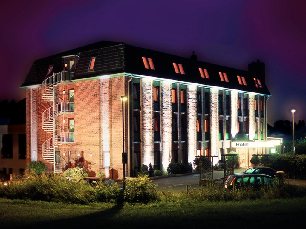 a large brick building with lights on it at night at Entrée Hotel Glinde in Hamburg